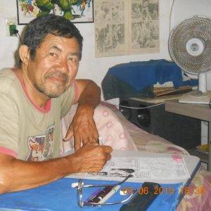 Foto de Luís Celso desenhando uma página de alguma História em Quadrinho.