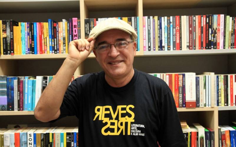 Foto de Wellington Soares na frente de uma estante de livros.