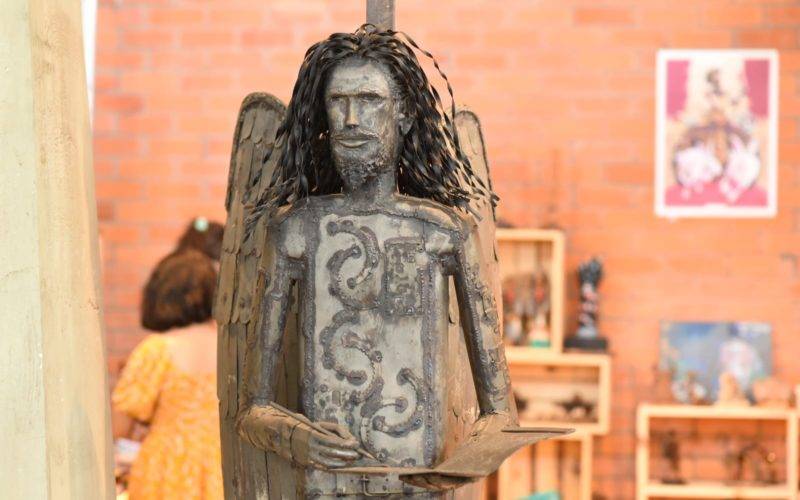 Foto do Cantinho da Geleia Total no Salipi de 2023. Em destaque uma escultura de Torquato Neto com asas de anjo torto.